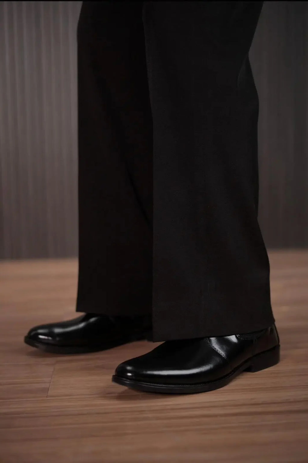 Men wearing black bell bottom bootcut dress pants with formal shoes – lower leg view